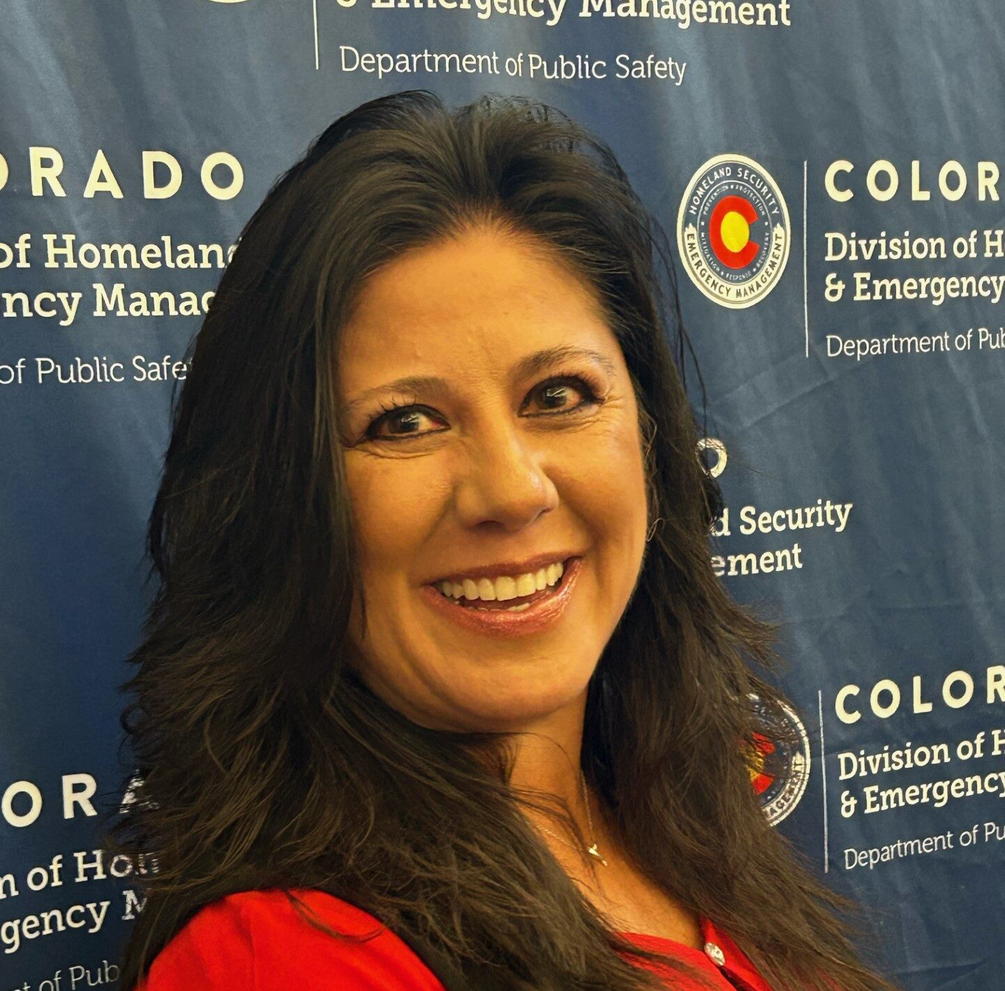 Sadie Martinez posed against a navy blue Colorado Division of Homeland Security and Emergency Management backdrop