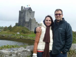 Woman and man standing in front of castle in Ireland.