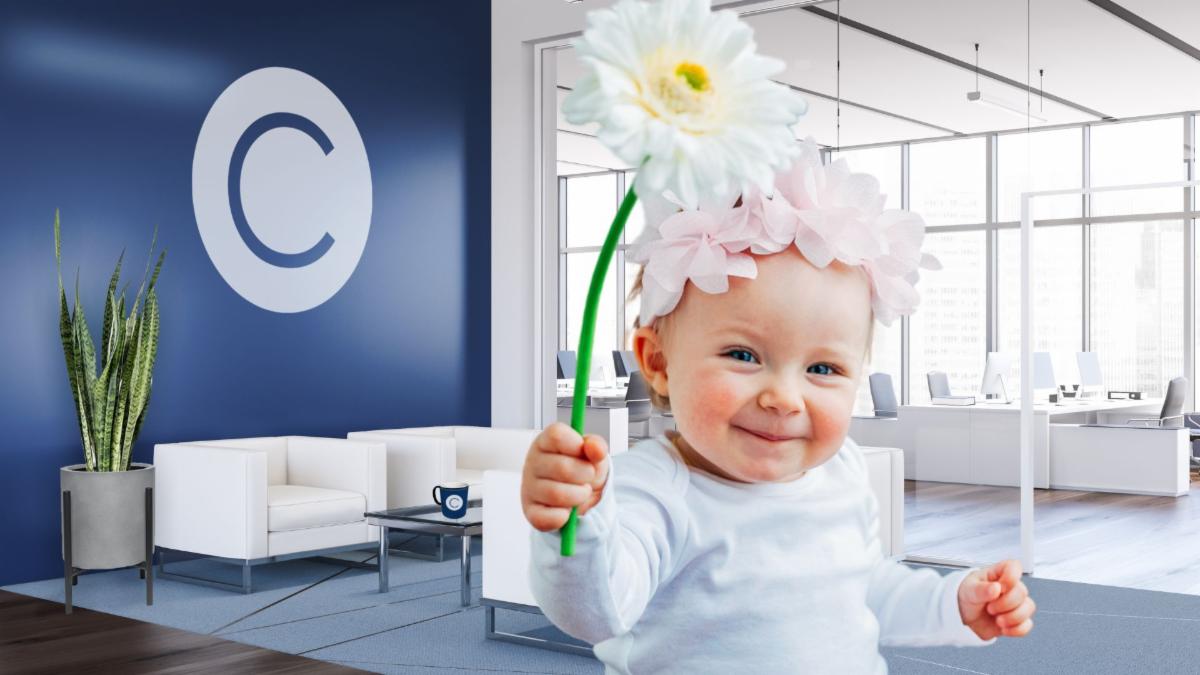 CONSTANT office background featuring a spotlighted baby with a flower on her head.